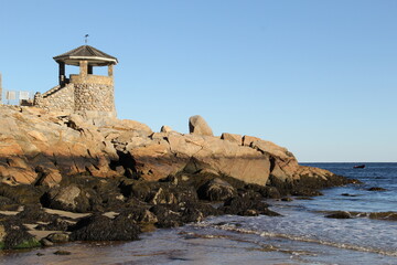 Fototapeta na wymiar stone lighthouse on a rocky ocean beach