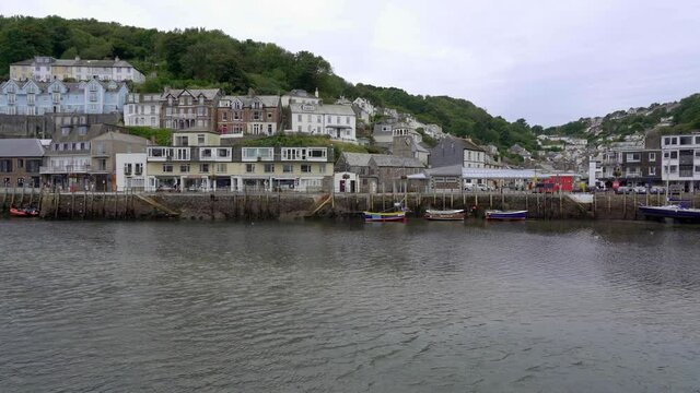 Panning shot looking across the Looe estuary to the historic fishing town of Looe, Cornwall, England, UK