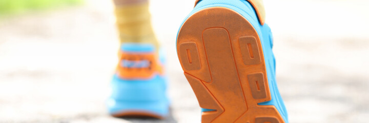 Leg of man taking step in sports sneakers closeup