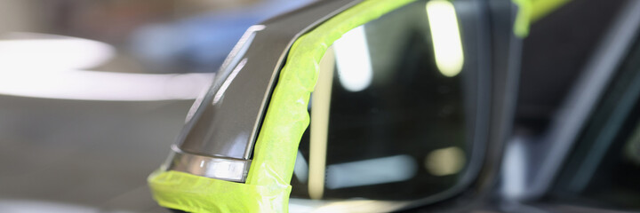 Side car mirror has green protective tape for polishing car