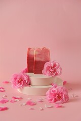 Obraz na płótnie Canvas Rose soap. Beauty and aromatherapy. Flower soap. Pink soap bars and pink roses on podium on pink background.Organic Soap with Rose extract .Organic vegan eco cosmetics.
