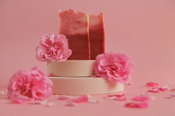 Rose soap. Beauty and aromatherapy. Flower soap. Pink soap bars and pink roses on podium on pink...