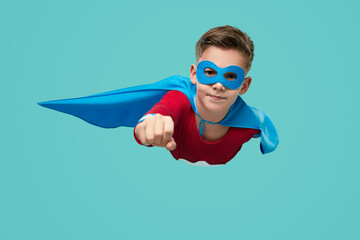 Superhero boy flying in studio