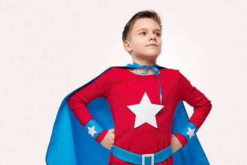 Brave superhero kid in costume in studio