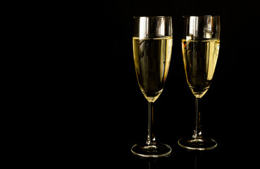 Two glasses of champagne. New Year's Eve celebration party, with copy space on black background.