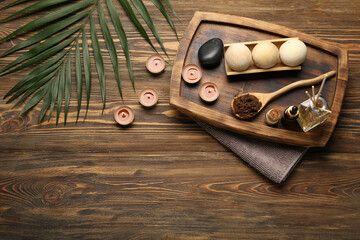 Beautiful spa composition with burning candles and palm leaf on wooden background