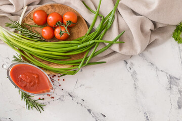 Gravy boat with organic tomato sauce and ingredients on white background