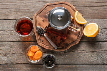 Obraz na płótnie Canvas Tea pot and glass of black tea on wooden background