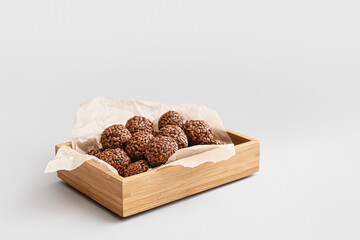 Box with tasty flax seed candies on light background