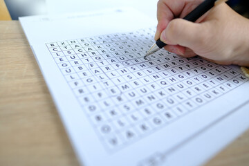 female hand close-up draws lines on paper, spell out and spell word in a square, concept of brain...