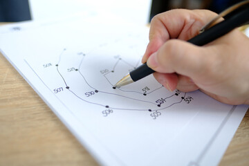 close-up female hand draws lines on paper, connects dots by numbers, concept of brain development...