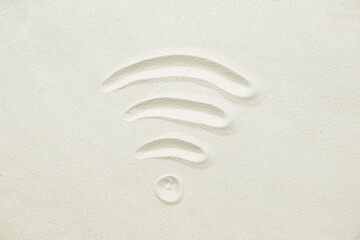 WiFi symbol on sand background, top view