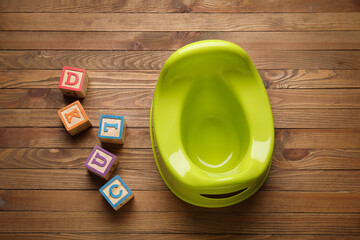 Potty and cubes with letters on wooden background