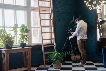 Male photographer working in stylish blue living room