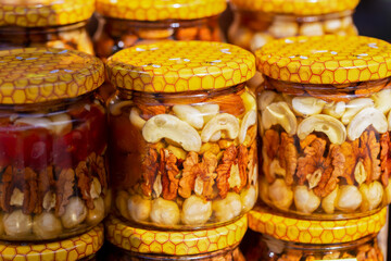 Nuts with fruits in honey, closed in jars