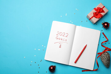 Open planner and Christmas decor on light blue background, flat lay with space for text. Planning...