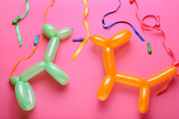 Dogs made of balloons and ribbons on pink background