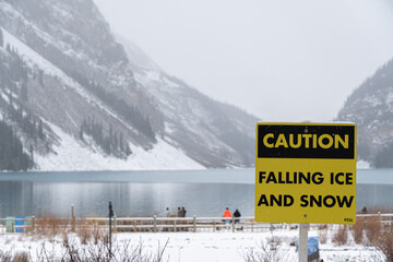 Falling Ice and Snow warning sign in national park during snowfall