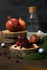 Beautiful red pomegranate fruit composition on a wooden background. Fresh ripe pomegranate selective focus. Pieces and grains of ripe pomegranate