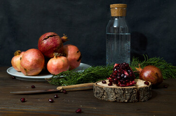 Beautiful red pomegranate fruit composition on a wooden background. Fresh ripe pomegranate selective focus. Pieces and grains of ripe pomegranate