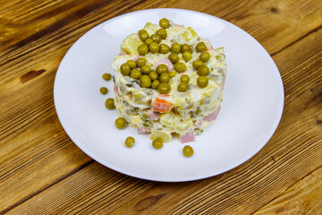 Traditional Russian festive salad Olivier on wooden table