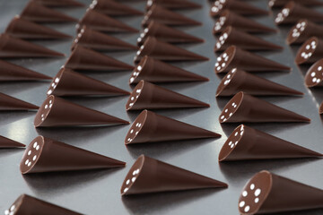 Many tasty chocolate candies on metal surface. Production line