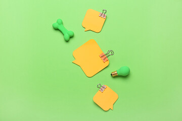 Sticky notes, binder clips and erasers on green background