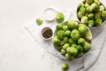 Bowls with fresh raw Brussels cabbage and spices on light background