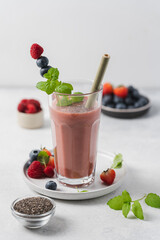 Glass of strawberry, blueberry and raspberry  smoothie on the table. Close-up and side view.