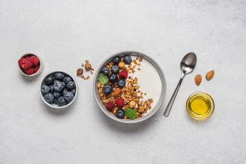 Bowl of yogurt with granola, blueberries, raspberries, almonds, hazelnuts. Homemade breakfast top view