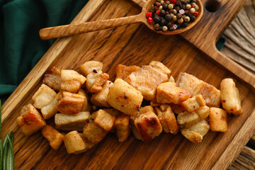 Board with tasty cracklings on wooden background