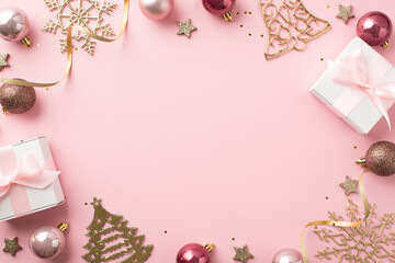 Top view photo of christmas decorations pink balls gold bell pine snowflake shaped ornaments white gift boxes stars serpentine sequins on isolated pastel pink background with copyspace mock up