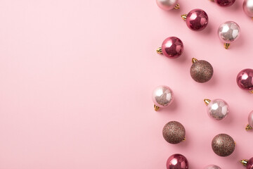 Top view photo of pink christmas tree decorations balls on isolated pastel pink background with empty space