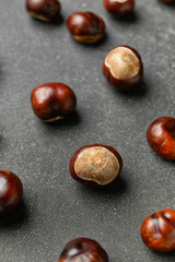 Many chestnuts on dark background, closeup