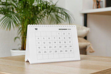 Paper calendar for December 2022 on table