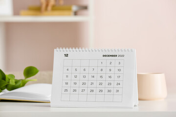 Paper calendar for December 2022 on table