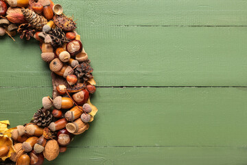 Beautiful acorn wreath on green wooden background © Pixel-Shot