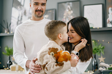 Happy young family spending time together in kitchen at home at Christmas