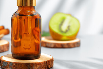 Fruit essential oil in glass bottle on gray background