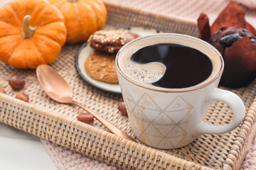 Cup of tasty pumpkin coffee on fabric background