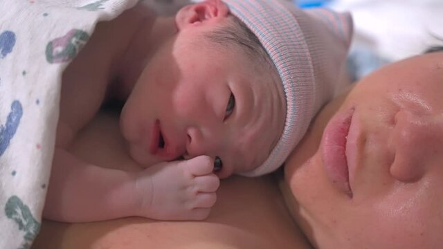 Asian Newborn Baby On Mother Right After Delivery