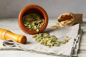 Mortar and pestle with pumpkin seeds on table