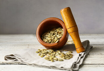 Mortar and pestle with pumpkin seeds on table