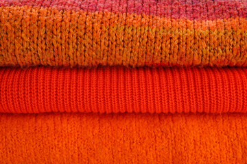 Stack of stylish sweaters as background