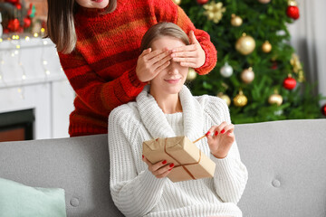 Young woman greeting her friend on Christmas eve at home