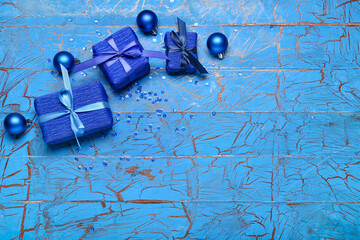 Fototapeta na wymiar Christmas gifts and decor on blue wooden background