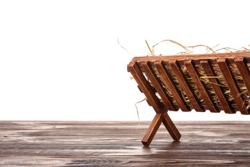 Wooden manger with hay on table against white background