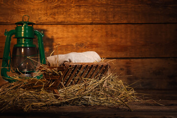 Fototapeta na wymiar Manger with baby and lantern on wooden background. Concept of Christmas story