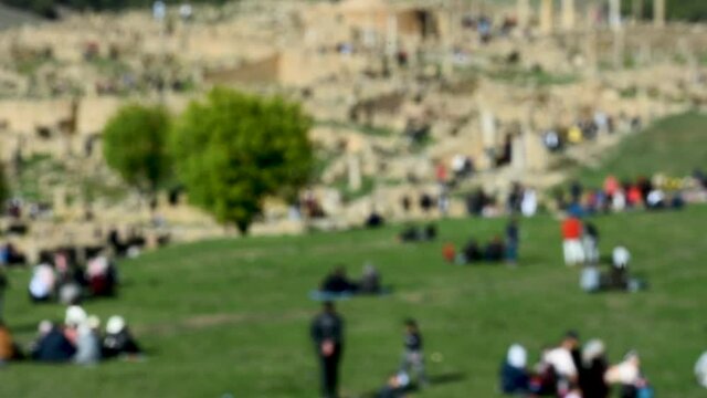 Blurred group of families enjoying spring day near Roman ruins in Djemila, Setif, Algeria