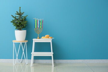 Menorah and donuts for Hanukkah celebration with Christmas tree in room